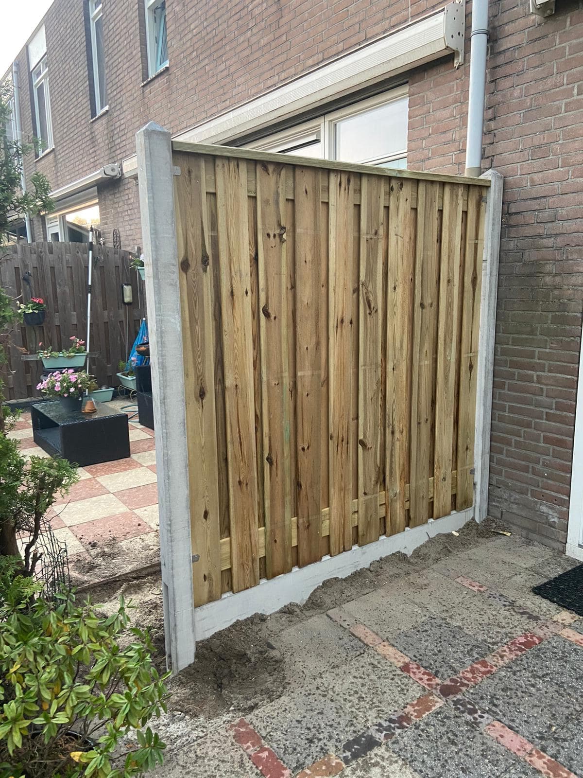 Houten schutting tegen betonnen palen